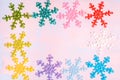 Crocheted multi-colored snowflakes. Crocheted doily. Handmade creativity. Bright christmas card on pink and purple background.