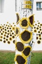 Crocheted sunflowers on a pole with additional flowers in the background. Royalty Free Stock Photo