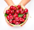 Crockery with cherries in woman hands.