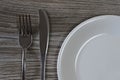 Crockery dish wear dishwear eating food diet weight loss slimming concept. Close up photo of knife, fork and white empty plate on Royalty Free Stock Photo