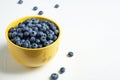 Crockery with juicy and fresh blueberries on white table