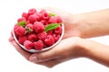 Crockery with raspberries in woman hands.