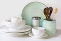 Crockery, tableware, utensils and other different white and turquoise stuff on white table-top. Kitchen still life as background f Royalty Free Stock Photo