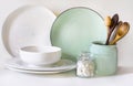 Crockery, tableware, utensils and other different white and turquoise stuff on white table-top. Kitchen still life as background f Royalty Free Stock Photo