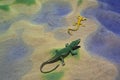 Crocodile toy on colored sand imitated desert