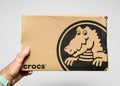 Crocs shoes cardboard box in men hands white background