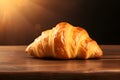 Croissant banner. Freshly baked croissant on a wooden table with a hint of sun rays. Crusty croissant on a wooden rustic table