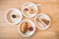 Croissant, Banoffee, Scone, Canele on paper plate on wooden table in the cafe