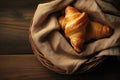 Croissant in a basket with cloth on a wooden table Royalty Free Stock Photo