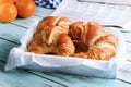 Croissant, orange, newspaper for breakfast on wooden surface