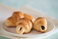 Croissant with chocolate on porcelain sauser