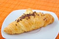 Croissant with chocolate on wooden background.