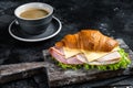 Croissant Club Sandwich with Ham and Cheese, cup of coffe. Black background. Top view Royalty Free Stock Photo