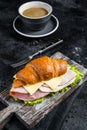 Croissant Club Sandwich with Ham and Cheese, cup of coffe. Black background. Top view Royalty Free Stock Photo