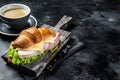 Croissant Club Sandwich with Ham and Cheese, cup of coffe. Black background. Top view. Copy space Royalty Free Stock Photo