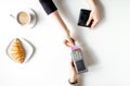 Croissant and coffee payment by card in cafe top view Royalty Free Stock Photo