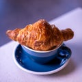 Croissant on cup of coffee. Marble background