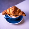 Croissant on cup of coffee. Marble background