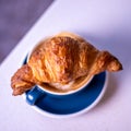 Croissant on cup of coffee. Marble background