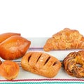 Croissant, muffin and other sweet pastries on rustic napkin isolated on white. Place for your text Royalty Free Stock Photo