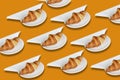 Croissant pattern with white plates and napkins on light brown background