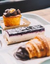 A croissant, a portion of cheesecake and a carrot cake muffin in a pastry shop Royalty Free Stock Photo