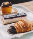 A croissant, a portion of cheesecake and a carrot cake muffin in a pastry shop Royalty Free Stock Photo