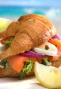 Croissant with salmon on the beach Royalty Free Stock Photo