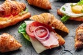 Croissant sandwich assortment. Various stuffed croissants on black