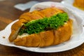 Croissant sandwich with cream cheese, meat and vegetables on a white plate. Concept of healthy breakfast Royalty Free Stock Photo