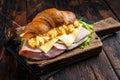 Croissant sandwich with egg cheese and green lettuce salad leaf, healthy breakfast. Wooden background. Top view Royalty Free Stock Photo