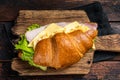 Croissant sandwich with egg cheese and green lettuce salad leaf, healthy breakfast. Wooden background. Top view Royalty Free Stock Photo