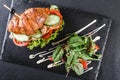 Croissant sandwich with fillet grilled chicken, fresh vegetables, cheese and greens on black shale board over black stone Royalty Free Stock Photo