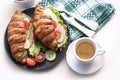 Croissant sandwich with ham, cheese, fresh salad, tomatoes and cup of tea Royalty Free Stock Photo