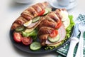 Croissant sandwich with ham, cheese and tomatoes on black plate Royalty Free Stock Photo