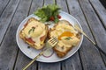 Croissant sandwich with poached egg, radish and salmon on plate in cafe Royalty Free Stock Photo