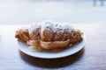 Croissant sandwich sprinkled with powdered sugar. Fast snack food