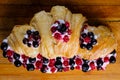 Croissant sandwiche with berries on a wooden background