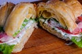 Croissant sandwiche with salmon red fish on a wooden background