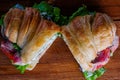Croissant sandwiche with salmon red fish on a wooden background
