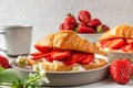 Croissant sandwiches with fresh ripe strawberries and cream cheese in a plate with cup of coffee for tasty breakfast Royalty Free Stock Photo