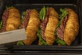 Croissant sandwiches stuffed with salami and herbs on the counter in the store. Unhealthy fast food. Close-up Royalty Free Stock Photo