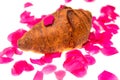 Croissant is showered with red rose leaves