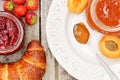 Croissant, strawberry jam, apricot jam on a decorative plate