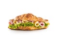 Croissant stuffed with lettuce salad ham and cheese isolated on white background