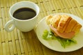 croissant stuffed pork bologna and green oak with black coffee