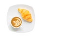 Croissant on white plate with Latte art on cappuccino coffee mug isolated over white background with clipping path. Croissant