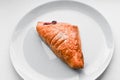 Croissant on a white plate. Croissant on white plate, top view. Sweat baked dessert in a dis