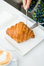 Croissant on a white porcelain plate with coffee on the side Royalty Free Stock Photo