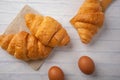 Croissants with coffee cups with flour and eggs on a white background, breakfast, brown bread, morning drinks, fantasy world: Royalty Free Stock Photo